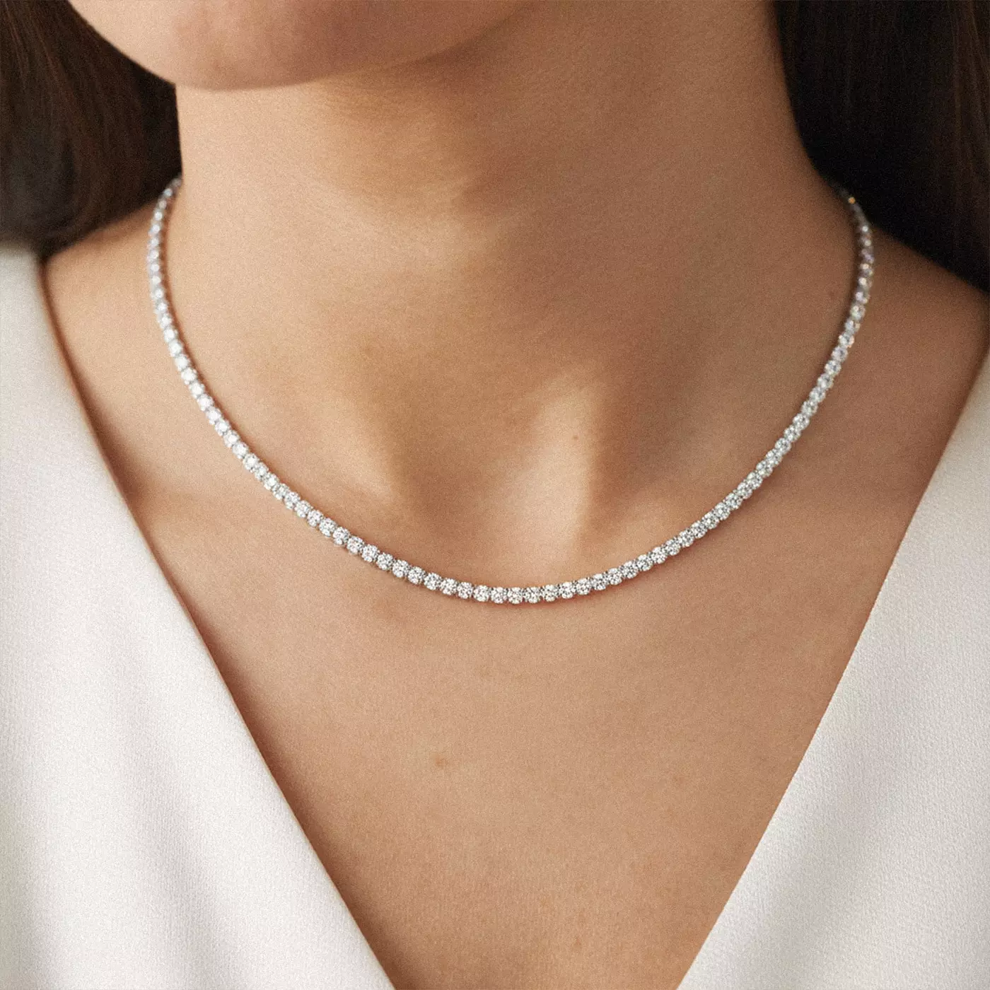 Classic Diamond Tennis Necklace featuring 7-carat lab diamonds, resting gracefully against the collarbone of the woman wearing it