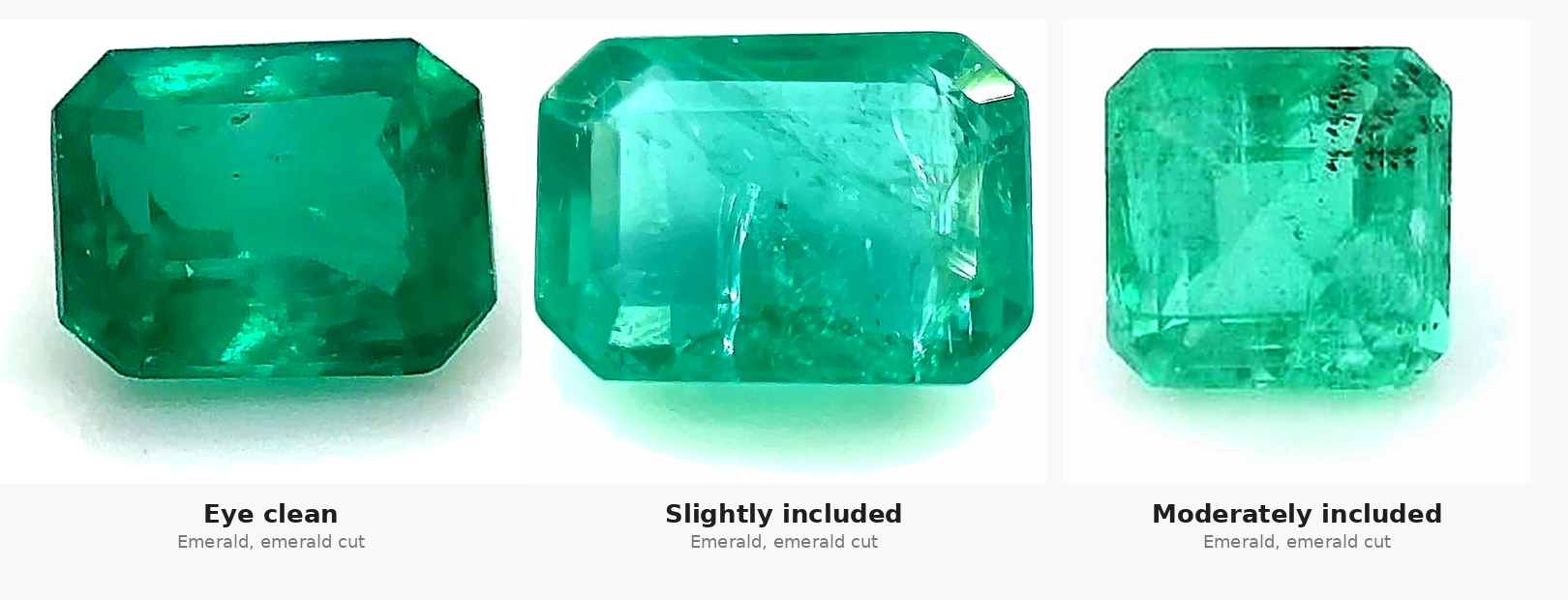 Three real emerald cut emeralds side by side showing actual clarity grades: eye clean with minimal inclusions, slightly included with visible white feathering, and moderately included with visible black inclusions.